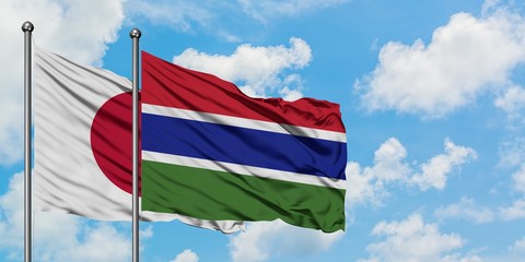 Japan and Gambia flag waving in the wind against white cloudy blue sky together. Diplomacy concept, international relations.