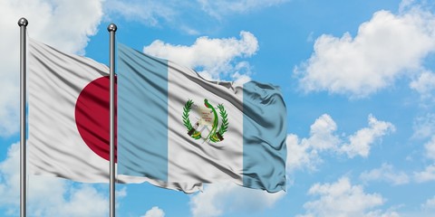 Japan and Guatemala flag waving in the wind against white cloudy blue sky together. Diplomacy concept, international relations.