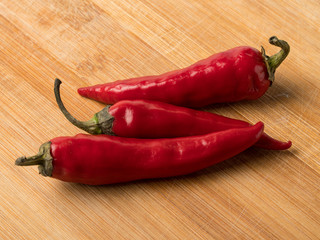 Background image of red hot chili peppers on a wooden cutting board