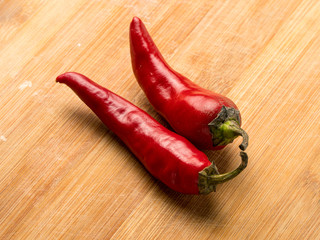 Background image of red hot chili peppers on a wooden cutting board