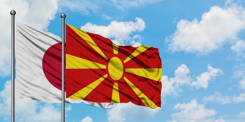 Japan and Macedonia flag waving in the wind against white cloudy blue sky together. Diplomacy concept, international relations.