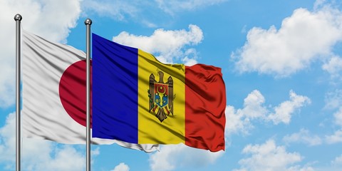 Japan and Moldova flag waving in the wind against white cloudy blue sky together. Diplomacy concept, international relations.