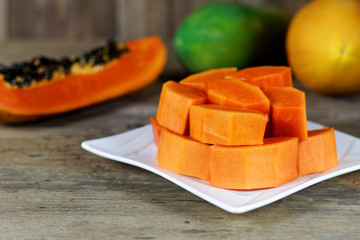 Sliced Ripe papaya fruit on white plate on wood background