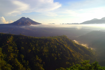 Der Vulkan Gunung Batur auf der Insel Bali morgens im Dunst vom Kraterrand aus aufgenommen