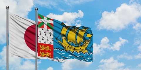 Japan and Saint Pierre And Miquelon flag waving in the wind against white cloudy blue sky together. Diplomacy concept, international relations.