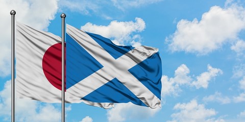 Japan and Scotland flag waving in the wind against white cloudy blue sky together. Diplomacy concept, international relations.