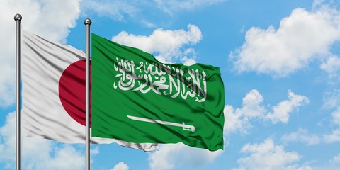 Japan and Saudi Arabia flag waving in the wind against white cloudy blue sky together. Diplomacy concept, international relations.