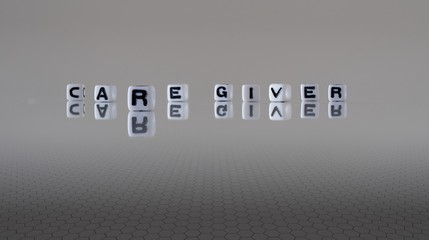 The concept of care giver represented by black and white plastic letter cubes