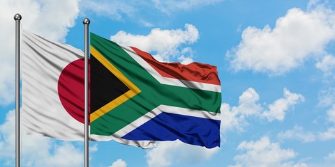 Japan and South Africa flag waving in the wind against white cloudy blue sky together. Diplomacy concept, international relations.