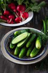A dish of fresh vegetables, cucumbers and radishes, spring onions