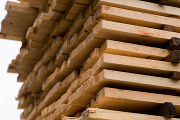 Piles of wooden boards in the sawmill, planking. Warehouse for sawing boards on a sawmill outdoors. Wood timber stack of wooden blanks construction material. Industry.