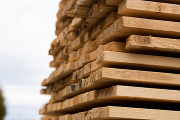 Piles of wooden boards in the sawmill, planking. Warehouse for sawing boards on a sawmill outdoors....