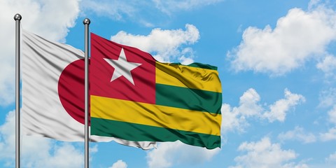 Japan and Togo flag waving in the wind against white cloudy blue sky together. Diplomacy concept, international relations.