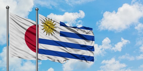 Japan and Uruguay flag waving in the wind against white cloudy blue sky together. Diplomacy concept, international relations.