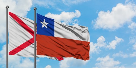 Jersey and Chile flag waving in the wind against white cloudy blue sky together. Diplomacy concept, international relations.