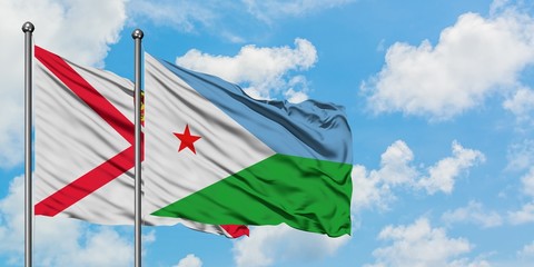 Jersey and Djibouti flag waving in the wind against white cloudy blue sky together. Diplomacy concept, international relations.