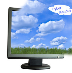Computer monitor with a carpet of green grass and blue sky with light clouds on the screen for the day of the Grand online sale cyber Monday