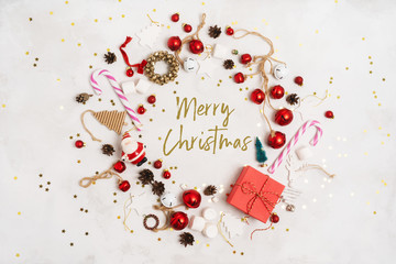 Merry Christmas and New Year text for greeting card, round frame, banner.  Happy Holidays Creative layout. Christmas props tree toys on white background top view. Winter holiday xmas theme.