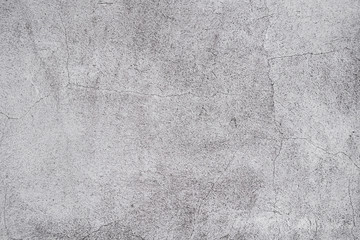 Cracked concrete grey wall covered with gray cement texture as background can be used in design. Dirty concrete texture with cracks and holes.