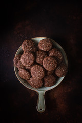 Chocolate cracked cookies with chocolate and sesame seeds. On a ceramic decorative dish