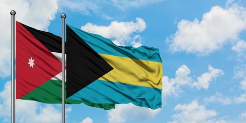 Jordan and Bahamas flag waving in the wind against white cloudy blue sky together. Diplomacy concept, international relations.