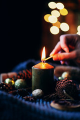 New Year or Christmas candle with cinnamon, cones, shiny balls on a dark background