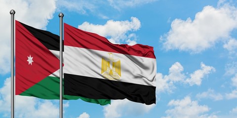 Jordan and Egypt flag waving in the wind against white cloudy blue sky together. Diplomacy concept, international relations.