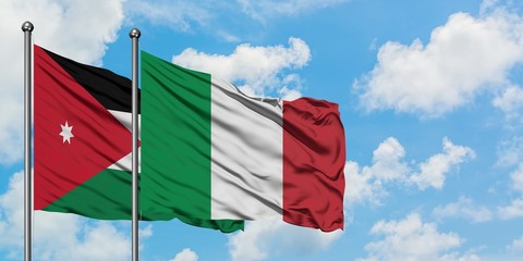 Jordan and Italy flag waving in the wind against white cloudy blue sky together. Diplomacy concept, international relations.