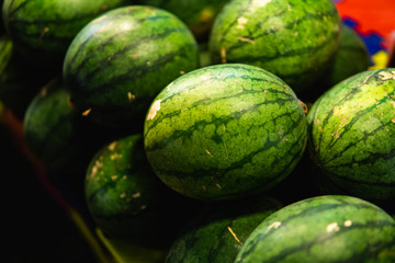 Ripe and sweet watermelons in the market. Close up. A lot of large ripe green striped watermelons. Organic farmer market, store.
