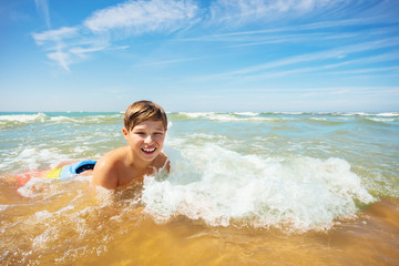 Fun in the wave boy lay on sea beach water edge
