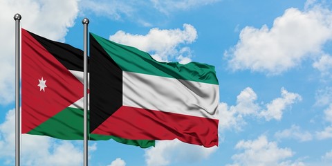 Jordan and Kuwait flag waving in the wind against white cloudy blue sky together. Diplomacy concept, international relations.