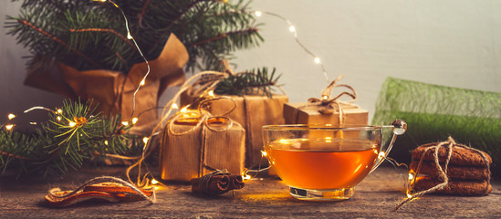 Cozy winter christmas at home. gifts in an eco-friendly package, a garland on a wooden table with warm plaids. Autumn lifestyle lagom hygge. Winter holiday and weekend concept, gift wrapping.Banner