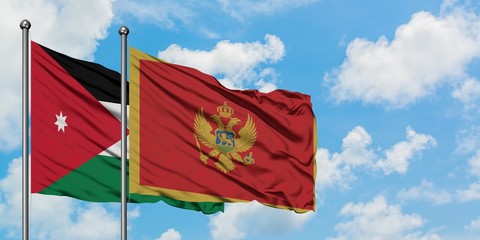 Jordan and Montenegro flag waving in the wind against white cloudy blue sky together. Diplomacy concept, international relations.