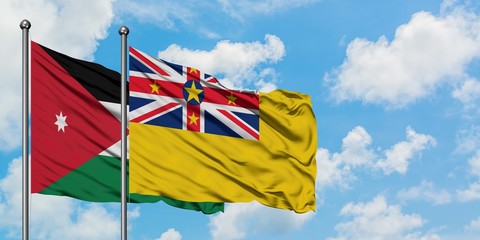 Jordan and Niue flag waving in the wind against white cloudy blue sky together. Diplomacy concept, international relations.