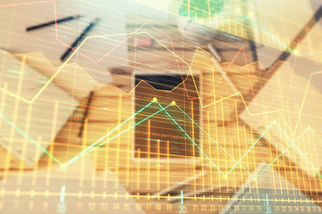 Double exposure of forex graph on digital tablet laying on table background. Concept of market analysis