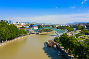 Fototapeta na wymiar Bridge of Peace in Tbilisi, Geaorgia, bow-shaped pedestrian bridge over the Kura River in Tbilisi, capital of Georgia. One of the most important sites of Tbilisi