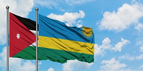 Jordan and Rwanda flag waving in the wind against white cloudy blue sky together. Diplomacy concept, international relations.