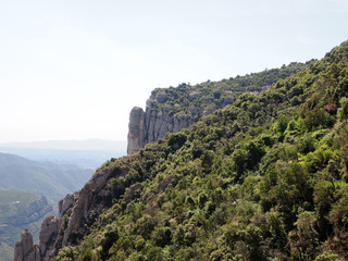 Fototapeta na wymiar Rocky slopes of Montserrat, covered with dense vegetation.