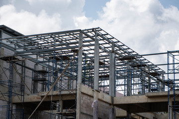 Building and Construction Site in progress. Building construction site against cloudy sky. Metal...
