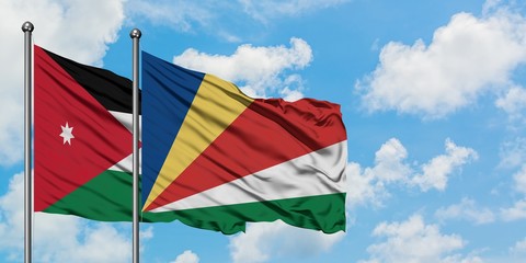 Jordan and Seychelles flag waving in the wind against white cloudy blue sky together. Diplomacy concept, international relations.