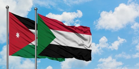 Jordan and Sudan flag waving in the wind against white cloudy blue sky together. Diplomacy concept, international relations.