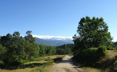 Fototapeta na wymiar Bergpanorama mit über die Berge quellende Wolken
