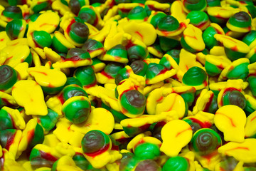 A pile of colorful marmalade candies in the form of helix yellow. green and red color. Sweet candy background