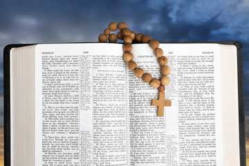 Open christianity bible and dark sky with clouds