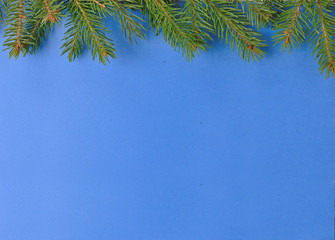 Obraz premium Christmas composition with Christmas tree branches and wooden decorations on a blue background