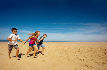 Children have fun run on the sand beach together