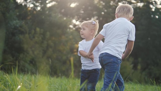 Happy family: funny slow motion video little kid boy hold hands play whirl a and girl brother and sister hold hand on lifestyle nature happy children concept. children happy family boy girl slow