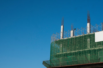 Building and Construction Site in progress. Building construction site against blue sky. Metal...