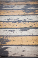 yellow and white stripes on a pedestrian crossing closeup