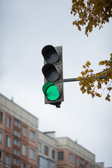 green traffic light on the sky background closeup